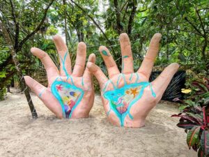 sculpture of two large hands at the ven a la luz tulum