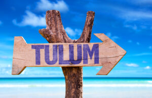 sign that says tulum in purple letters