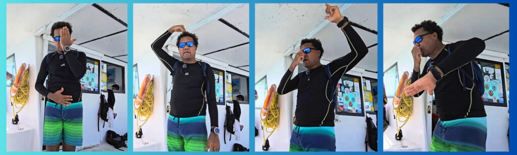 A man demonstrates underwater hand signals on a boat, wearing snorkeling gear and showing various gestures for communication while diving.