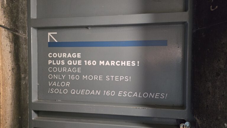 A motivational sign indicating that there are 160 steps remaining, featuring messages in English, French, and Spanish.