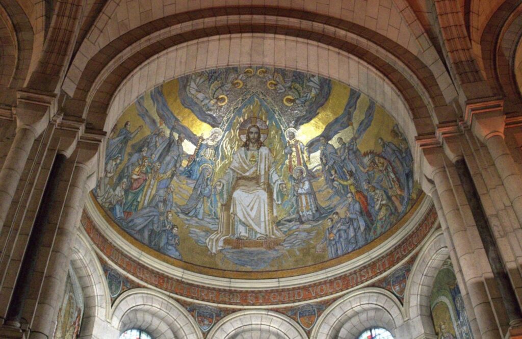 A vibrant mosaic depicting Christ seated in glory, surrounded by angels and saints, featured in an ornate church interior.
