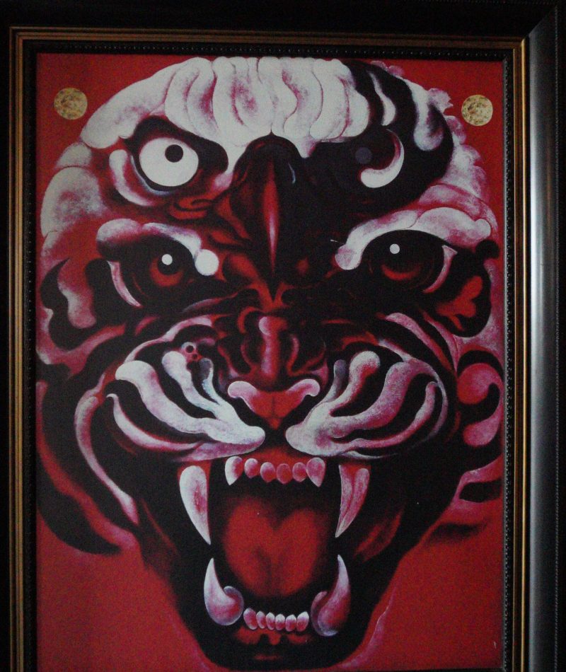 Baan Dam: The Black House Museum A striking artwork featuring a roaring tiger's face on a vibrant red background, showcasing intense expressions and bold colors.