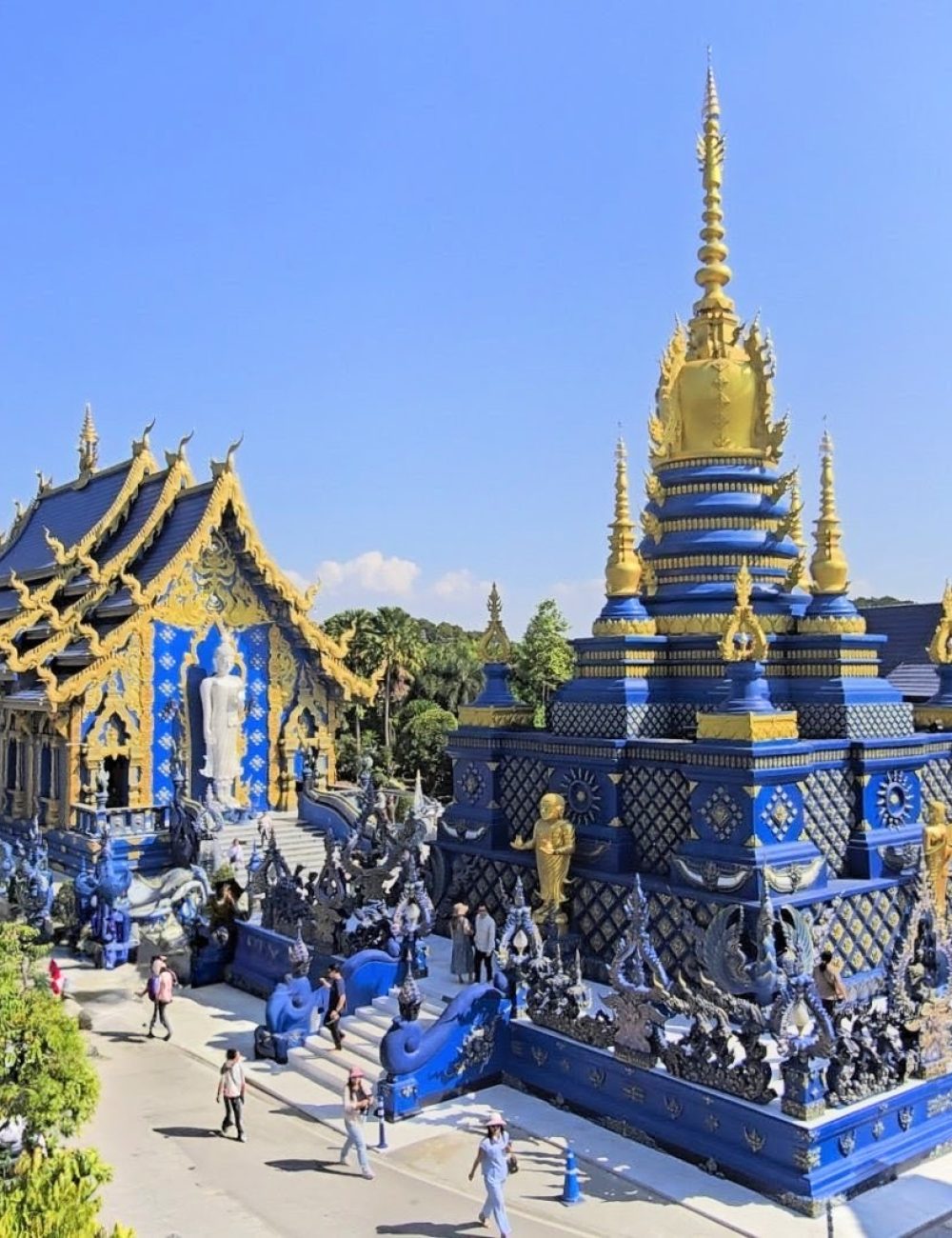 The White Temple, Chiang Rai A panoramic view of the stunning Blue Temple, featuring intricate blue and gold architecture alongside visitors exploring the site.