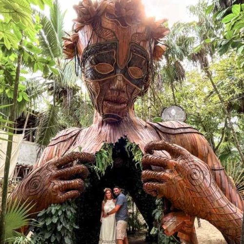two people at the ven a la luz sculpture in tulum
